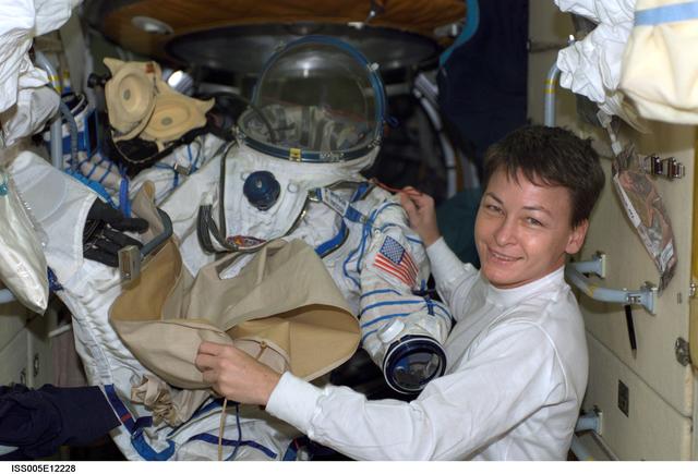 NASA image: Whitson holds Russian Sokol suit in the FGB during Expedition Five on the ISS