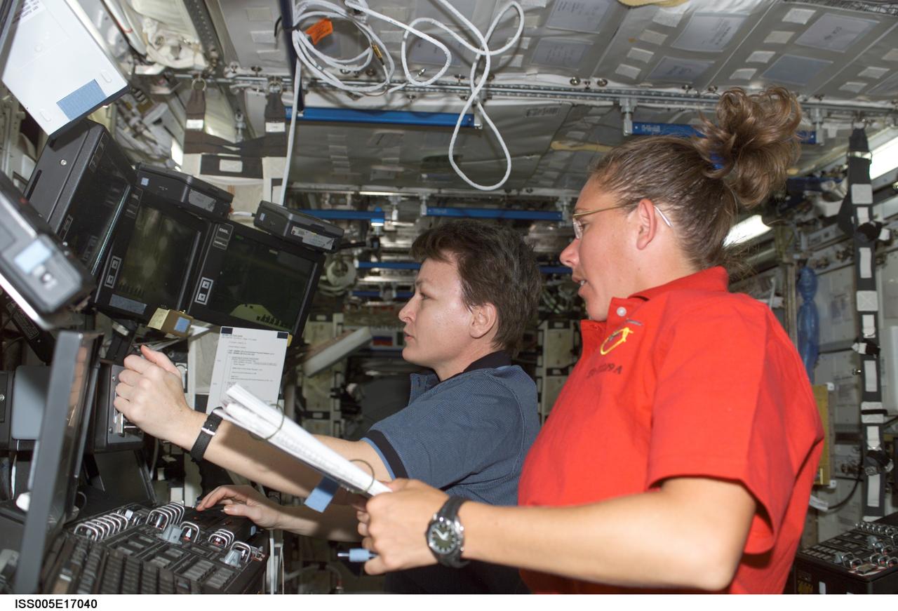 ISS005-E-17040 (10 October 2002) --- Astronauts Peggy A. Whitson (background), Expedition Five flight engineer, and Sandra H. Magnus, STS-112 mission specialist, work the controls of the Canadarm2 from inside the Destiny laboratory on the International Space Station (ISS).  Whitson and Magnus used the station&#0146;s robotic arm to lift the Starboard One (S1) Truss out of the Atlantis&#0146; payload bay and move it into position on the starboard end of the S0 (S-Zero) Truss.