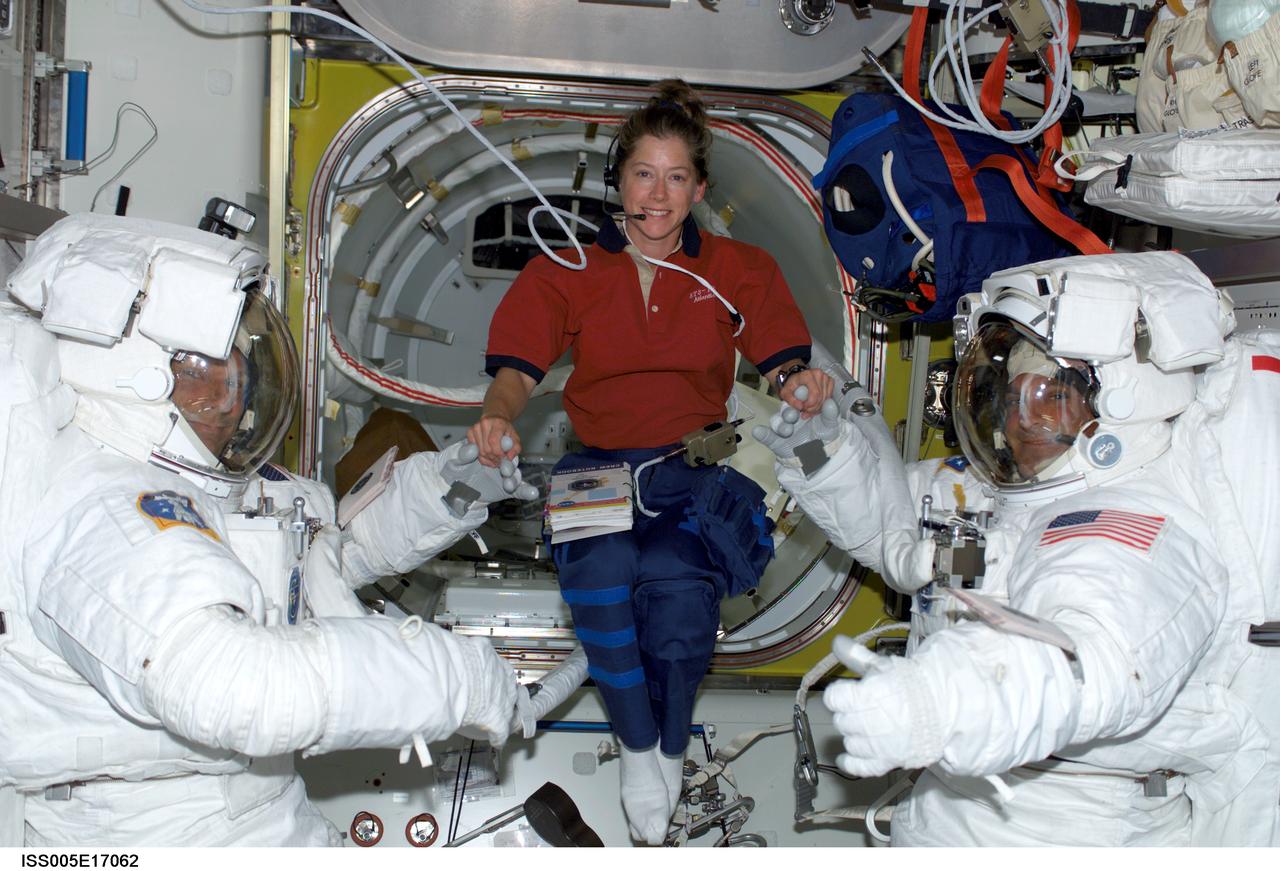 ISS005-E-17062 (10 October 2002) --- Astronauts Piers J. Sellers (left) and David A. Wolf, STS-112 mission specialists attired in their Extravehicular Mobility Unit (EMU) space suits, are photographed in the Quest Airlock on the International Space Station (ISS) prior to the first scheduled session of extravehicular activity (EVA). Astronaut Pamela A. Melroy, pilot, was visible in the center.