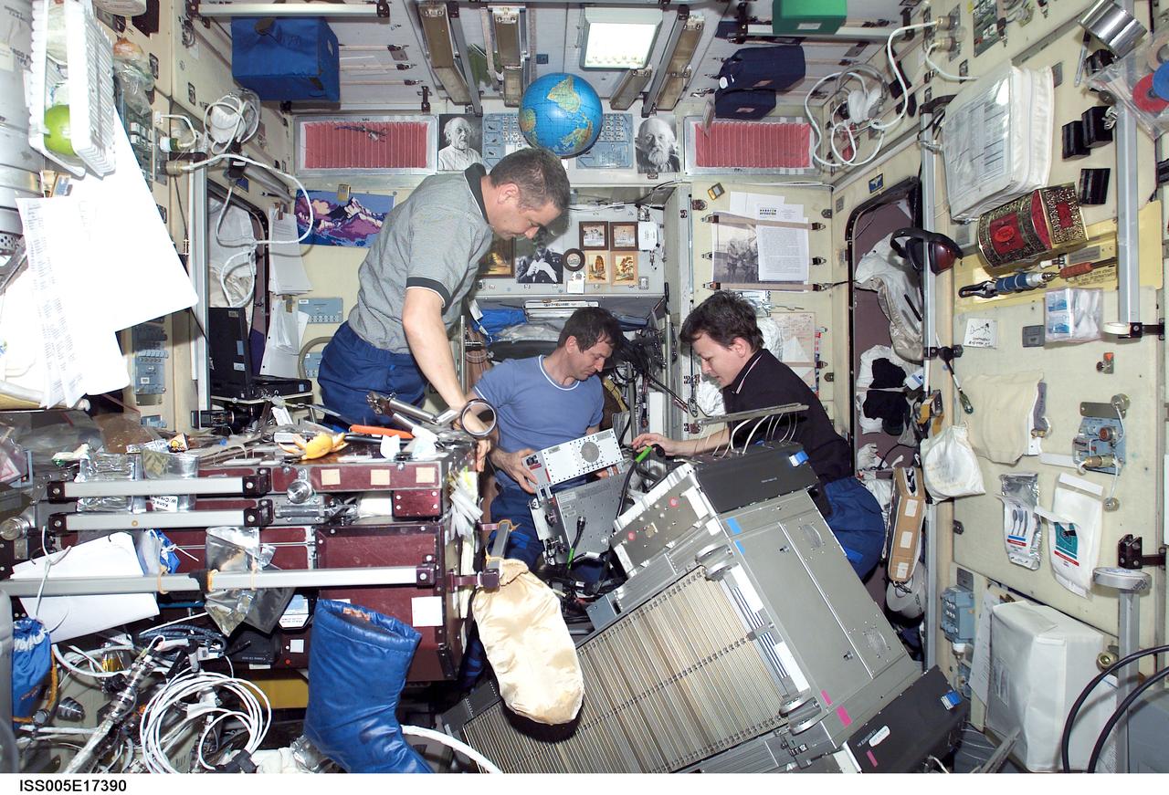ISS005-E-17390 (13 October 2002) --- Cosmonauts Valery G. Korzun (left), Expedition Five mission commander, Sergei Y. Treschev and astronaut Peggy A. Whitson, Expedition Five flight engineers, perform maintenance on the Treadmill Vibration Isolation System (TVIS) in the Zvezda Service Module on the International Space Station (ISS). Korzun and Treschev represent Rosaviakosmos.