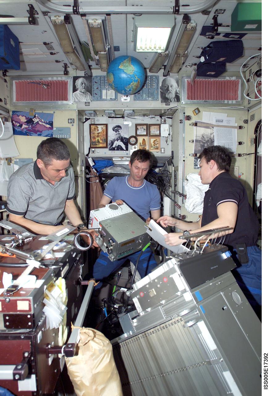 ISS005-E-17392 (13 October 2002) --- Cosmonauts Valery G. Korzun (left), Expedition Five mission commander, Sergei Y. Treschev and astronaut Peggy A. Whitson, Expedition Five flight engineers, perform maintenance on the Treadmill Vibration Isolation System (TVIS) in the Zvezda Service Module on the International Space Station (ISS). Korzun and Treschev represent Rosaviakosmos.