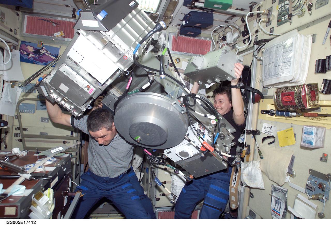 ISS005-E-17412 (13 October 2002) --- Cosmonaut Valery G. Korzun (left), Expedition Five mission commander, and astronaut Peggy A. Whitson, Expedition Five flight engineer, perform maintenance on the Treadmill Vibration Isolation System (TVIS) in the Zvezda Service Module on the International Space Station (ISS). Korzun represents Rosaviakosmos.