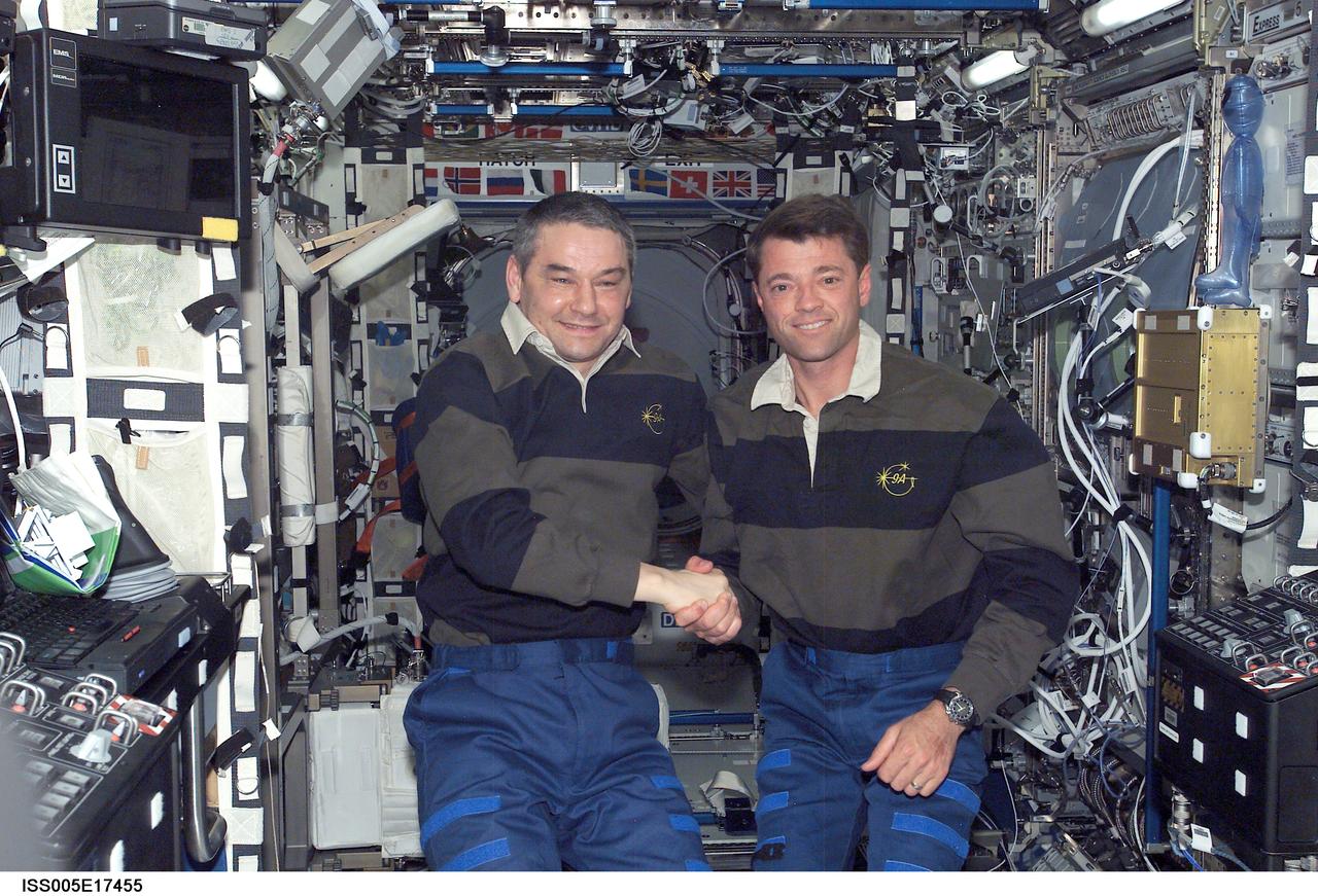 ISS005-E-17455 (13 October 2002) --- Cosmonaut Valery G. Korzun (left), Expedition Five mission commander, and astronaut Jeffrey S. Ashby, STS-112 mission commander, pose for a photo in the Destiny laboratory on the International Space Station (ISS). Korzun represents Rosaviakosmos.