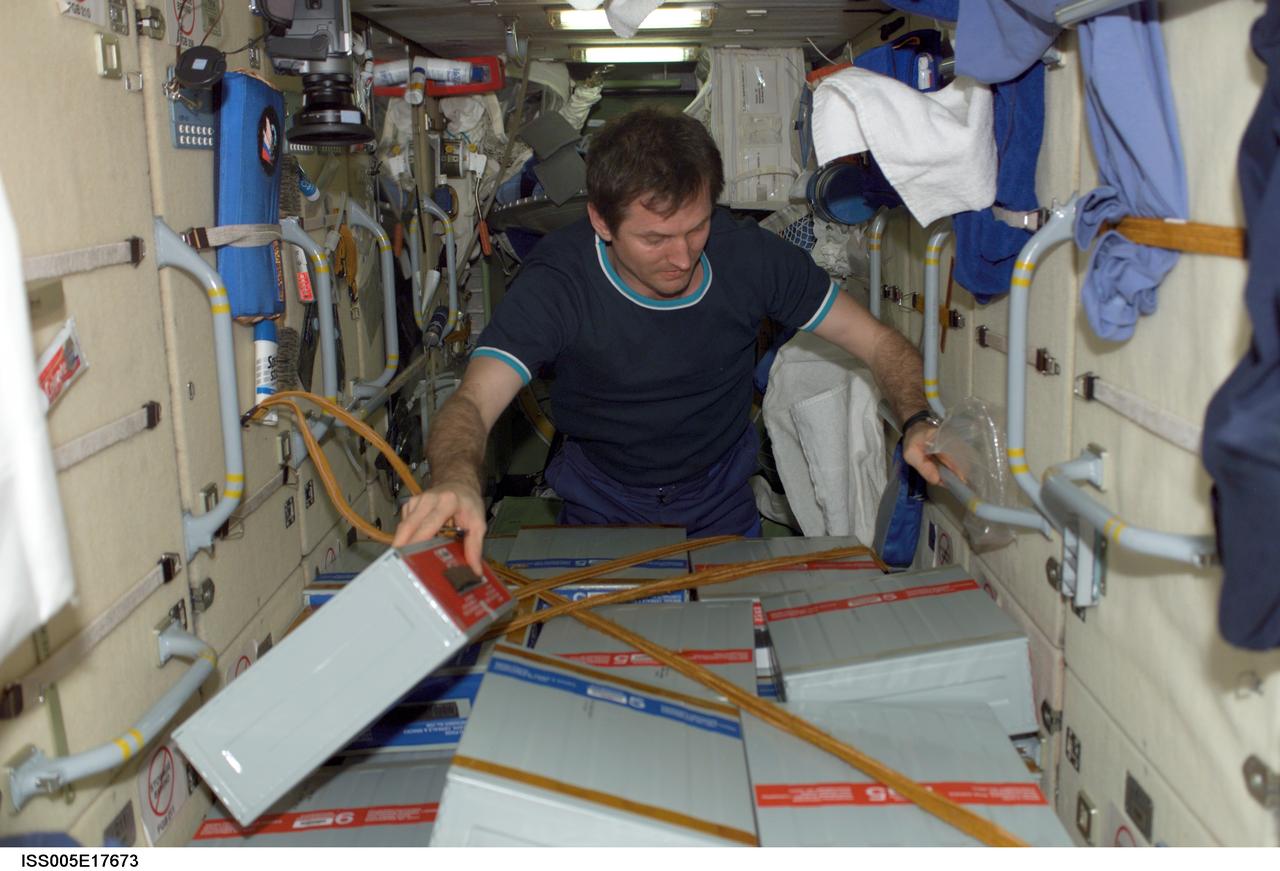 ISS005-E-17673 (17 October 2002) --- Cosmonaut Sergei Y. Treschev, Expedition Five flight engineer representing Rosaviakosmos, checks stowage boxes in the functional cargo block (FGB), or Zarya, on the International Space Station (ISS).