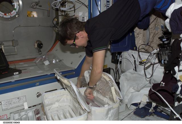 NASA image: Whitson retrieves an experiment cartridge for the ZCG experiment in the U.S. Laboratory