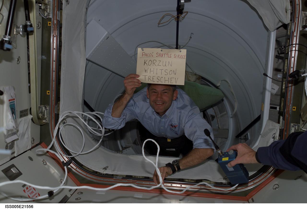 ISS005-E-21556 (25 November 2002) --- Astronaut Paul S. Lockhart, STS-113 pilot, holds a sign as he floats through the Pressurized Mating Adapter 2 (PMA-2) on the International Space Station (ISS) following the docking with the Space Shuttle Endeavour. Lockhart was also STS-111 pilot, which carried the Expedition Five crew to the station.