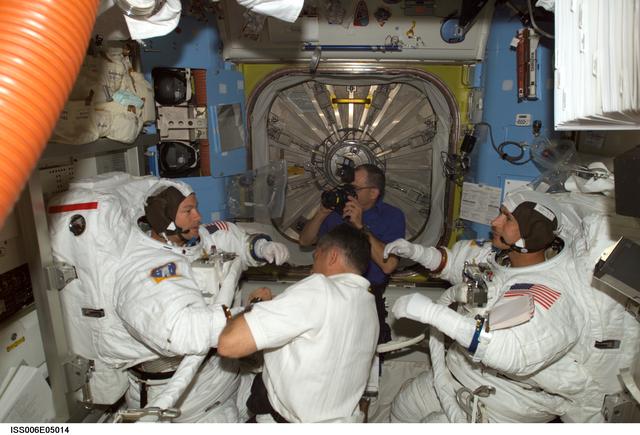 NASA image: STS-113 Pilot Lockhart is assisting MS Lopez-Alegria and MS Herrington with their EMU Spacesuits