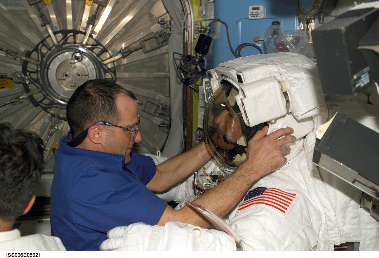 ISS006-E-05021 (28 November 2002) --- Astronaut Donald R. Pettit, NASA ISS science officer, assists astronaut John B. Herrington, STS-113 mission specialist, with his Extravehicular Mobility Unit (EMU) spacesuit in the Quest Airlock on the International Space Station (ISS).