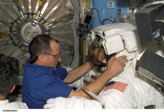 NASA image: Expedition Six Flight Engineer Pettit is adjusting the helmet on STS-113 MS Herringtons EMU