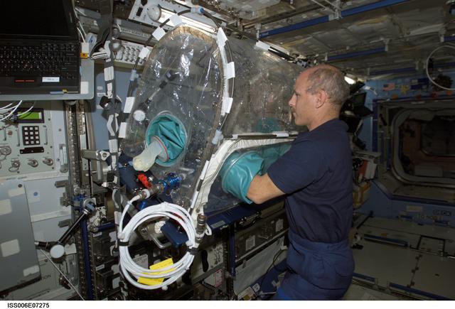 NASA image: Expedition Six Commander Bowersox works with an experiment in a portable glovebox facility