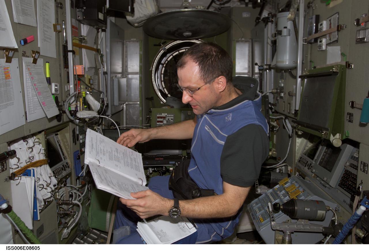 ISS006-E-08605 (18 December 2002) --- Astronaut Donald R. Pettit, Expedition Six NASA ISS science officer, looks over a procedures checklist in the Zvezda Service Module on the International Space Station (ISS).
