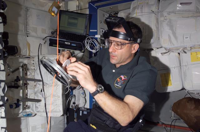 NASA image: Pettit conducts maintenance on the RED equipment in the U.S. Laboratory