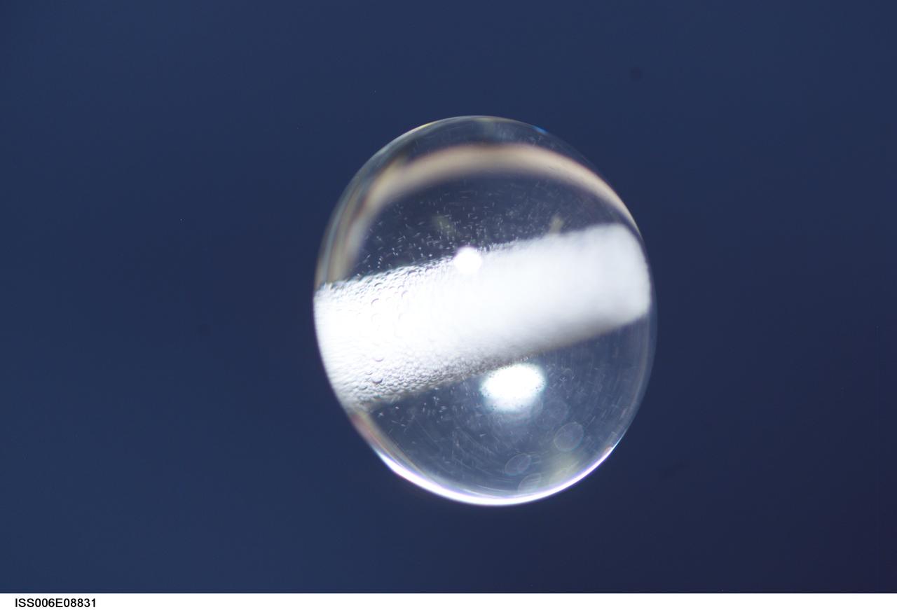ISS006-E-08831 (14 December 2002) --- View of a bubble formed as a result of a Zeolite Crystal Growth (ZCG) experiment in the Destiny laboratory on the International Space Station (ISS). Expedition Six Commander Kenneth D. Bowersox used a Space Station drill to mix 12 Zeolite samples in clear tubes. Scientists on the ground watching on TV noticed bubbles in the samples. Bowersox used a modified mixing procedure to process autoclaves to isolate bubbles.  He re-inserted the samples in the ZCG furnace in Express Rack 2 in the U.S. laboratory/Destiny. This experiment has shown that the bubbles could cause larger number of smaller deformed crystals to grow. Bowersox rotated the samples so that the heavier fluid was thrown to the outside while the lighter bubbles stayed on the inside.