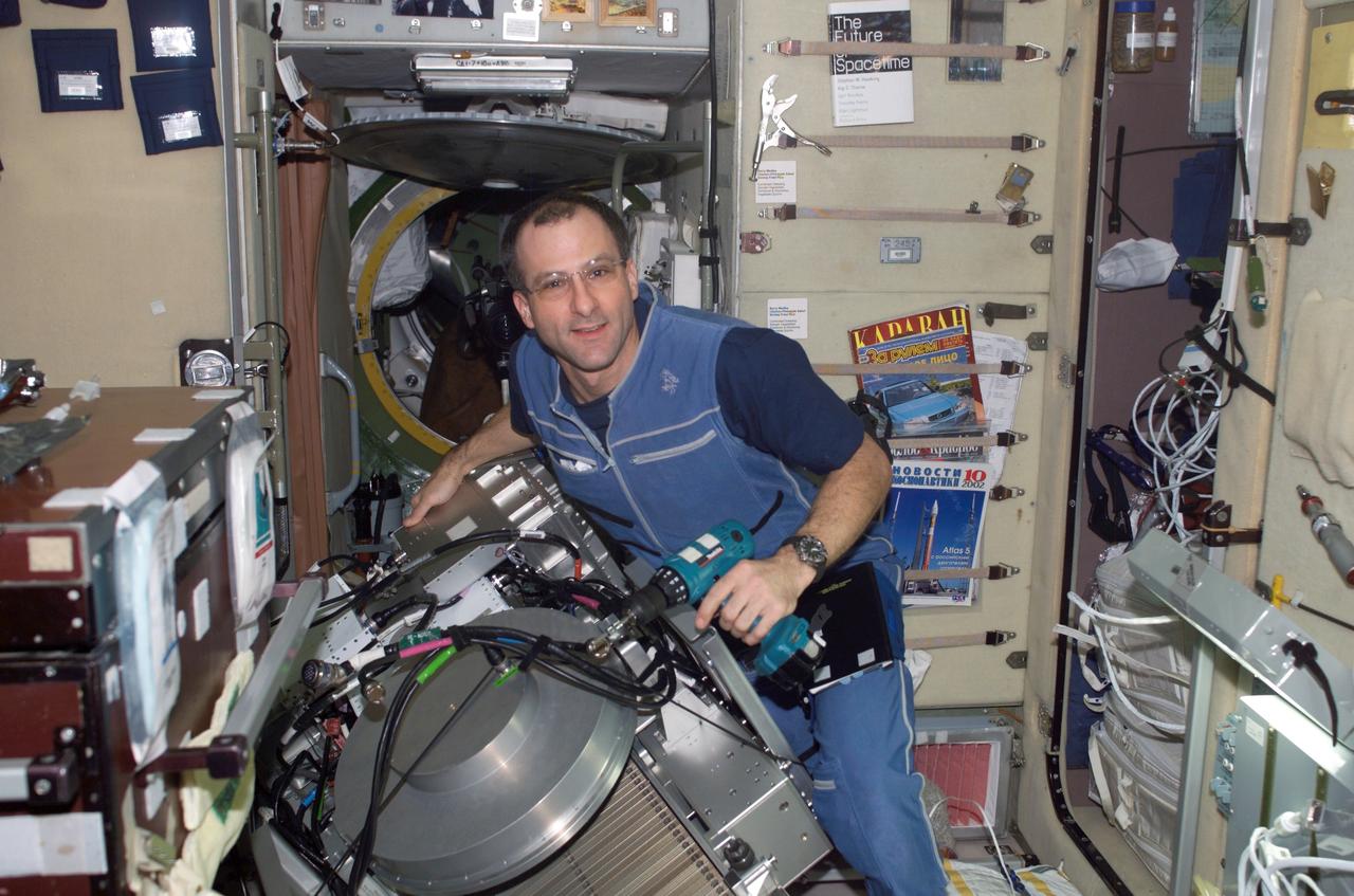 ISS006-E-18234 (7 January 2003) --- Astronaut Donald R. Pettit, Expedition 6 NASA ISS science officer, performs in-flight maintenance (IFM) on the Treadmill Vibration Isolation System (TVIS) in the Zvezda Service Module on the International Space Station (ISS).