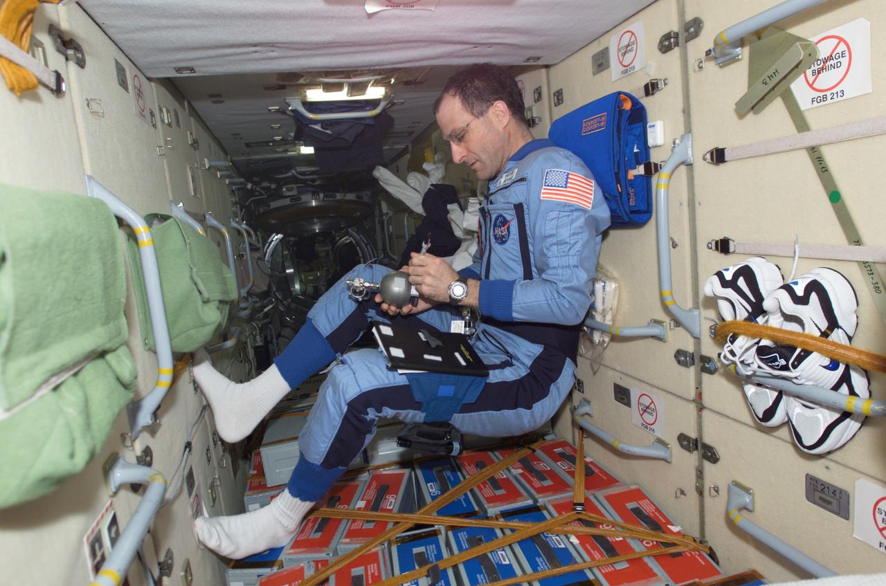 ISS006-E-20835 (22 January 2003) --- Astronaut Donald R. Pettit, Expedition 6 NASA ISS science officer, holds a Grab Sample Container (GSC) in the functional cargo block (FGB), or Zarya, on the International Space Station (ISS). GSC is used for collecting air samples as part of ISS environmental monitoring.