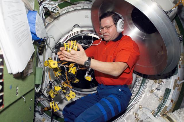 NASA image: Budarin works with clamps in the Transfer Chamber of Zvezda during Expedition Six