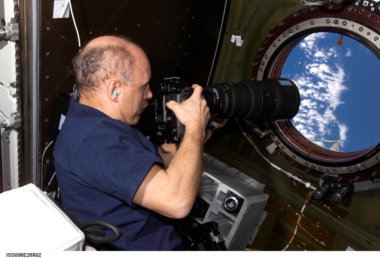 ISS006-E-26802 (14 February 2003) --- Astronaut Kenneth D. Bowersox, Expedition Six mission commander, uses a still camera to photograph the topography of a point on Earth from the nadir window in the Destiny laboratory on the International Space Station (ISS).