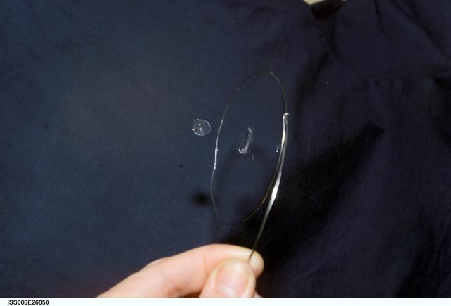 NASA image: View of a surface tension demonstration using water that is being held in place by a 50mm metal loop