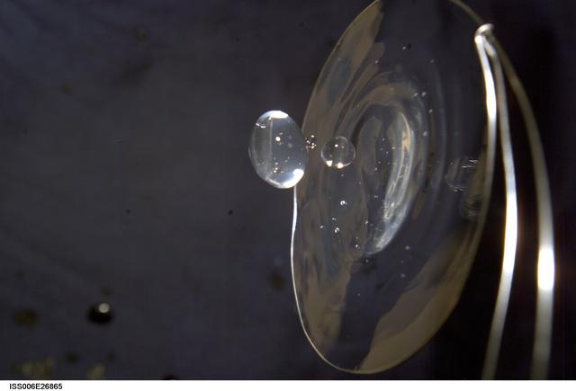 NASA image: View of a surface tension demonstration using water that is being held in place by a 50mm metal loop