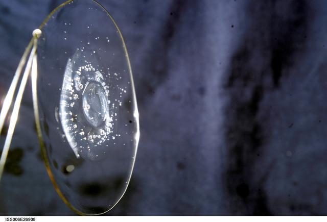 NASA image: View of a surface tension demonstration using water that is being held in place by a 50mm metal loop