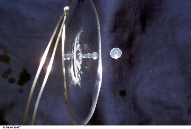 NASA image: View of a surface tension demonstration using water that is being held in place by a 50mm metal loop