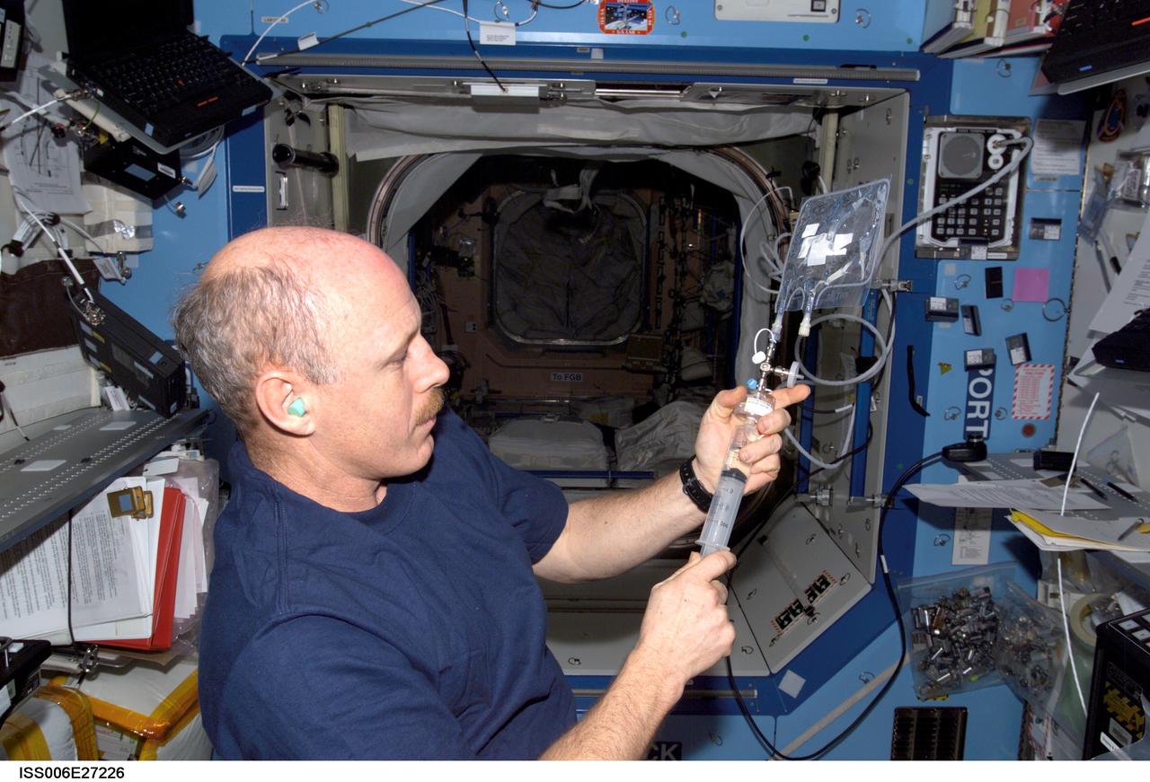 ISS006-E-27226 (17 February 2003) --- Astronaut Kenneth D. Bowersox, Expedition Six mission commander, uses the water microbiology kit (WMK) to collect water samples for in-flight chemistry/microbiology analysis in the Destiny laboratory on the International Space Station (ISS).