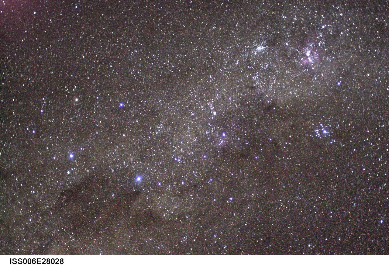 ISS006-E-28028 (February 2003) --- The Southern Cross (left center), the Coal Sack Nebula (bottom left), and the Carina Nebula (upper right) are visible in this view photographed by astronaut Donald R. Pettit, Expedition Six NASA ISS science officer, on board the International Space Station (ISS). The Carina Nebula is a molecular cloud about 9000 light years from Earth where young stars are forming. The Coal Sack Nebula is an inky-black dust cloud about 2000 light years from Earth. Stars are probably condensing deep inside the Coal Sack, but their light has not yet broken through the cloud&#0146;s dense exterior. The Southern Cross, also known as The Crux, is a constellation familiar to southern hemisphere stargazers.