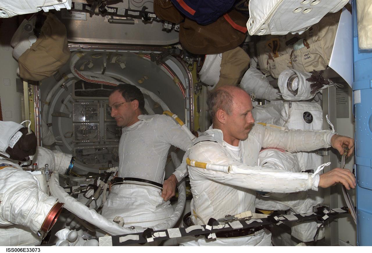 ISS006-E-33073 (24 February 2003) --- Astronauts Kenneth D. Bowersox (right) and Donald R. Pettit, Expedition Six mission commander and NASA ISS science officer, respectively, participate in a scheduled extravehicular activity (EVA) development test objective (DTO) in the Quest Airlock on the International Space Station (ISS). The test demonstrated the ability of two crewmembers to safely get into the American Extravehicular Mobility Unit (EMU) spacesuit without the assistance of a third crewmember; that ability is a prerequisite to sending smaller crews to ISS while the space shuttle fleet remains grounded during the investigation of the Columbia accident. Bowersox and Pettit helped each other into their EMU spacesuits, donned jet backpacks called Simplified Aid for EVA Rescue (SAFER), set up the necessary equipment for a pre-breathe of oxygen to purge nitrogen from their bloodstreams, and then got out of the spacesuits.