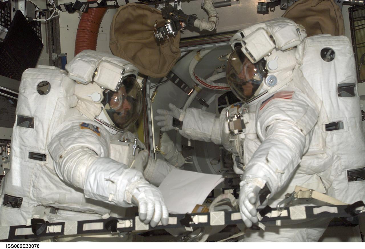 ISS006-E-33078 (24 February 2003) --- Astronauts Kenneth D. Bowersox (right) and Donald R. Pettit, Expedition Six mission commander and NASA ISS science officer, respectively, participate in a scheduled extravehicular activity (EVA) development test objective (DTO) in the Quest Airlock on the International Space Station (ISS). The test demonstrated the ability of two crewmembers to safely get into the American Extravehicular Mobility Unit (EMU) spacesuit without the assistance of a third crewmember; that ability is a prerequisite to sending smaller crews to ISS while the space shuttle fleet remains grounded during the investigation of the Columbia accident. Bowersox and Pettit helped each other into their EMU spacesuits, donned jet backpacks called Simplified Aid for EVA Rescue (SAFER), set up the necessary equipment for a pre-breathe of oxygen to purge nitrogen from their bloodstreams, and then got out of the spacesuits.