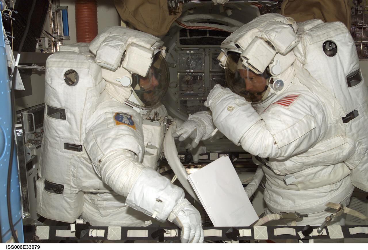 ISS006-E-33079 (24 February 2003) --- Astronauts Kenneth D. Bowersox (right) and Donald R. Pettit, Expedition Six mission commander and NASA ISS science officer, respectively, participate in a scheduled extravehicular activity (EVA) development test objective (DTO) in the Quest Airlock on the International Space Station (ISS). The test demonstrated the ability of two crewmembers to safely get into the American Extravehicular Mobility Unit (EMU) spacesuit without the assistance of a third crewmember; that ability is a prerequisite to sending smaller crews to ISS while the space shuttle fleet remains grounded during the investigation of the Columbia accident. Bowersox and Pettit helped each other into their EMU spacesuits, donned jet backpacks called Simplified Aid for EVA Rescue (SAFER), set up the necessary equipment for a pre-breathe of oxygen to purge nitrogen from their bloodstreams, and then got out of the spacesuits.