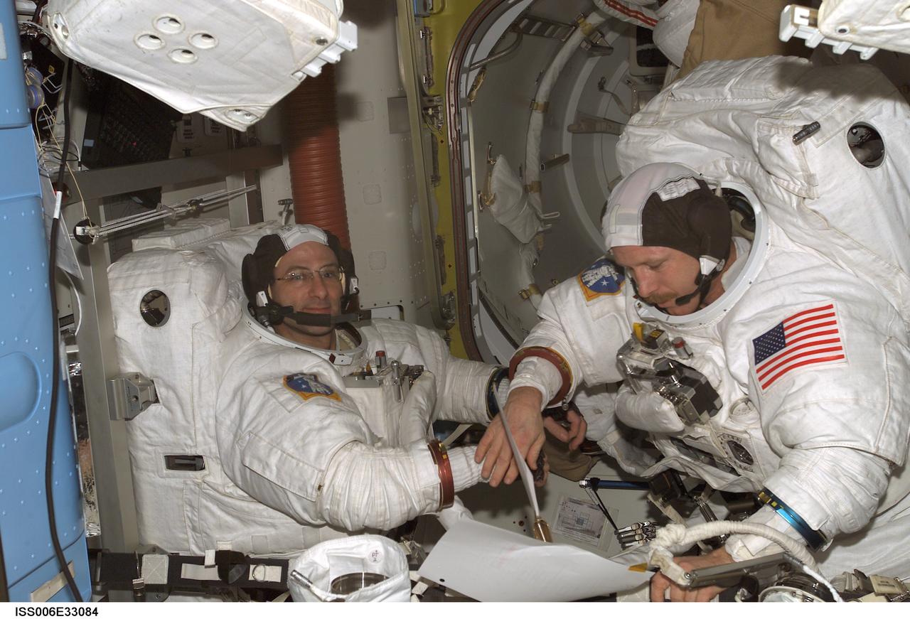 ISS006-E-33084 (24 February 2003) --- Astronauts Kenneth D. Bowersox (right) and Donald R. Pettit, Expedition Six mission commander and NASA ISS science officer, respectively, participate in a scheduled extravehicular activity (EVA) development test objective (DTO) in the Quest Airlock on the International Space Station (ISS). The test demonstrated the ability of two crewmembers to safely get into the American Extravehicular Mobility Unit (EMU) spacesuit without the assistance of a third crewmember; that ability is a prerequisite to sending smaller crews to ISS while the space shuttle fleet remains grounded during the investigation of the Columbia accident. Bowersox and Pettit helped each other into their EMU spacesuits, donned jet backpacks called Simplified Aid for EVA Rescue (SAFER), set up the necessary equipment for a pre-breathe of oxygen to purge nitrogen from their bloodstreams, and then got out of the spacesuits.