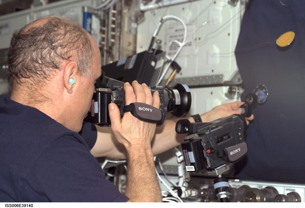 ISS006-E-39140 (12 March 2003) --- Astronaut Kenneth D. Bowersox, Expedition Six mission commander, photographs a water bubble within a 50-millimeter metal loop. The experiment took place in the Destiny laboratory on the International Space Station (ISS).