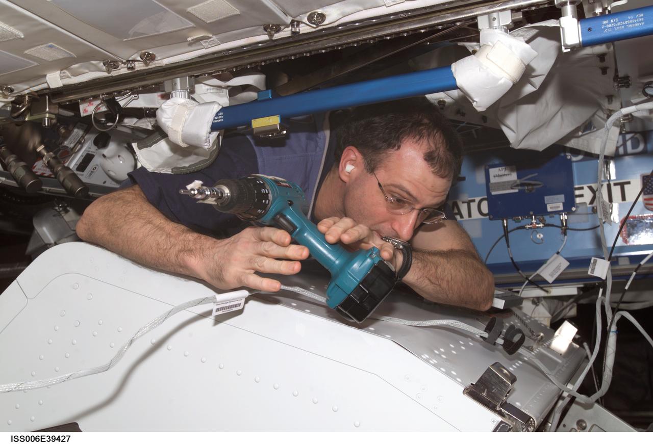 ISS006-E-39427 (17 March 2003) --- Astronaut Donald R. Pettit, Expedition Six NASA ISS science officer, uses a drill to disassemble framework of the Internal Thermal Control System (ITCS) in the Destiny laboratory on the International Space Station (ISS).