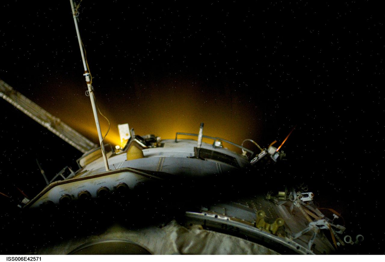 ISS006-E-42571 (4 April 2003) --- This view features a reboost of the International Space Station (ISS) in action. Ground controllers at Mission Control Moscow ignited the thrusters of a Progress rocket docked to the station&#0146;s Zvezda Service Module. The 14-minute firing raised the average altitude of the station by about 3 km. One of the Expedition 6 crewmembers captured this picture of the yellow-glowing thrusters from a window in the Service Module.