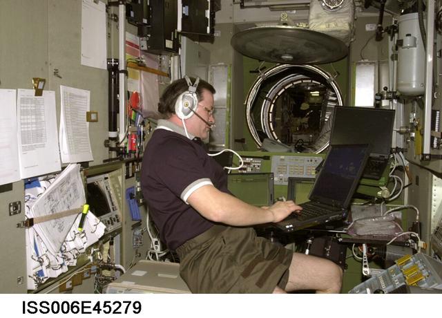 ISS006-E-45279 (21 March 2003) --- Cosmonaut Nikolai M. Budarin, Expedition Six flight engineer, uses a computer as he talks on a communication system in the Zvezda Service Module on the International Space Station (ISS). Budarin represents Rosaviakosmos.