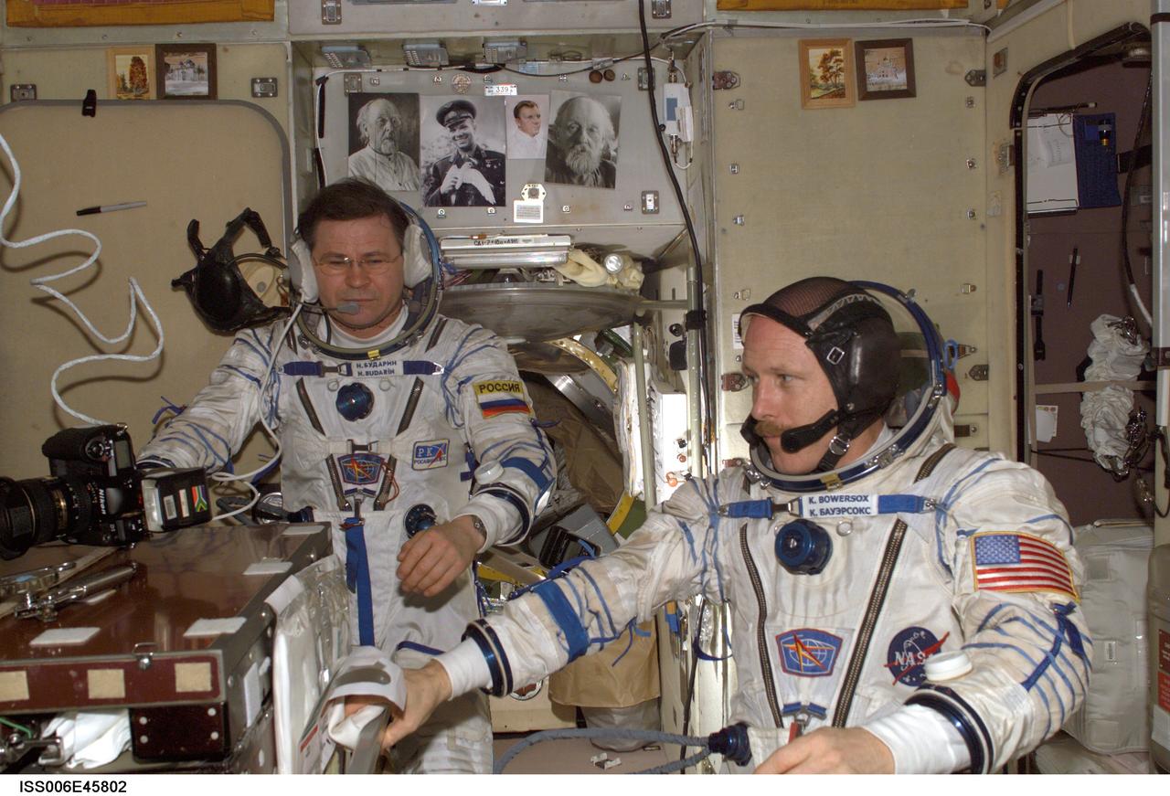 ISS006-E-45802 (14 April 2003) --- Attired in their Russian Sokol suits, astronaut Kenneth D. Bowersox (right), Expedition Six mission commander, and cosmonaut Nikolai M. Budarin, flight engineer, are pictured in the Zvezda Service Module on the International Space Station (ISS). The crewmembers were practicing for their return flight home scheduled for May 3, 2003 onboard the Soyuz TMA-1 spacecraft.