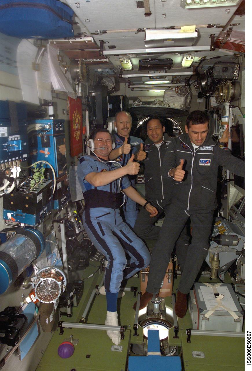 ISS006-E-50607 (28 April 2003) --- The Expedition Seven crewmembers pose with two of the Expedition Six crewmembers (blue suits) in the Zvezda Service Module on the International Space Station (ISS), photographed by astronaut Donald R. Pettit (out of view), Expedition Six NASA ISS science officer. From the left are cosmonaut Nikolai M. Budarin, Expedition Six flight engineer; astronaut Kenneth D. Bowersox, Expedition Six mission commander; astronaut Edward T. Lu, Expedition Seven NASA ISS science officer and flight engineer; and cosmonaut Yuri I. Malenchenko, Expedition Seven mission commander. Budarin and Malenchenko represent Rosaviakosmos.