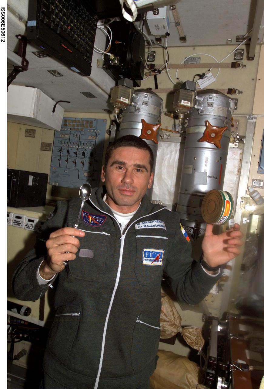 ISS006-E-50612 (28 April 2003) --- Cosmonaut Yuri I. Malenchenko, Expedition Seven mission commander, is pictured holding a spoon while a can of food floats nearby in the Zvezda Service Module on the International Space Station (ISS). Malenchenko represents Rosaviakosmos.