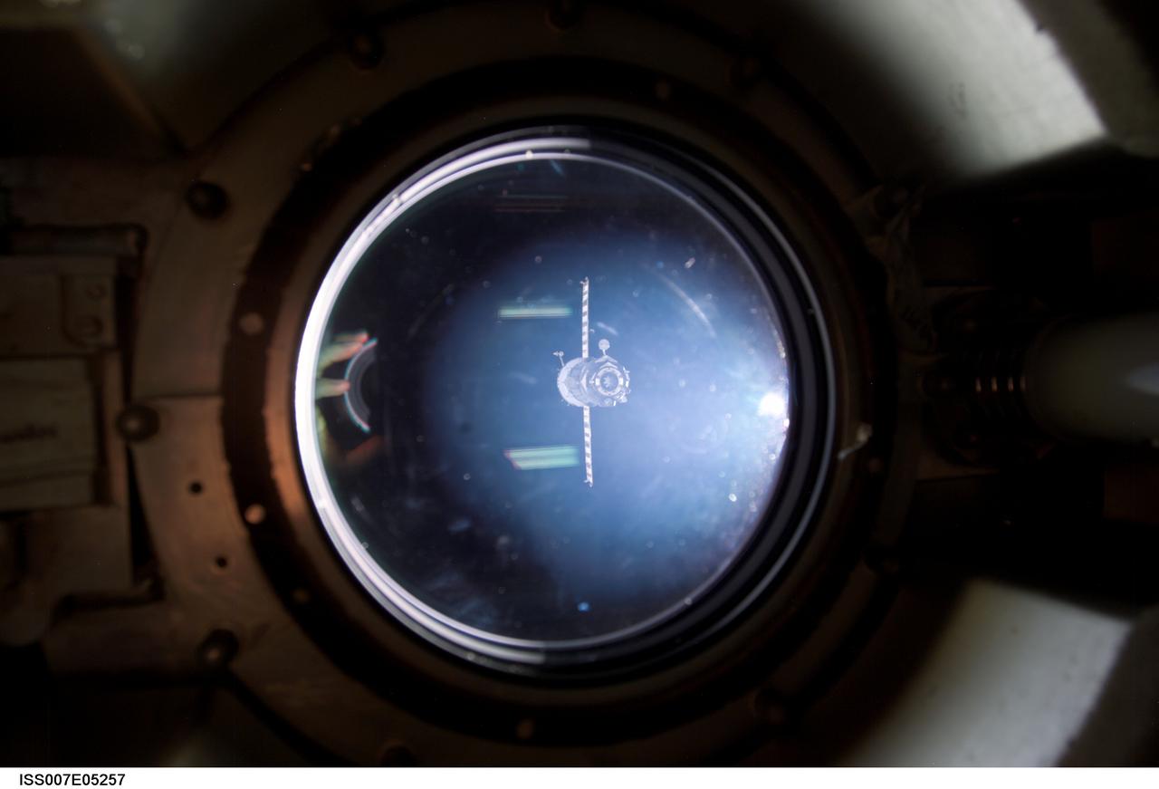 ISS007-E-05257 (3 May 2003) --- As seen through a window on the International Space Station (ISS), the Soyuz TMA-1 capsule departs from the station carrying the Expedition Six crewmembers, astronauts Kenneth D. Bowersox, mission commander; Donald R. Pettit, NASA ISS science officer; and cosmonaut Nikolai M. Budarin, flight engineer representing Rosaviakosmos.