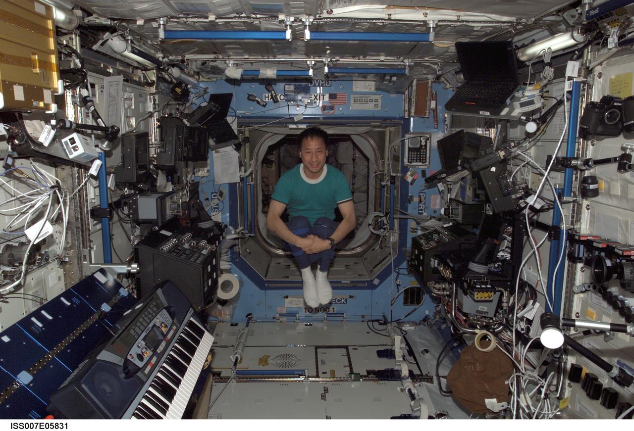 ISS007-E-05831 (22 May 2003) --- Astronaut Edward T. Lu, Expedition Seven NASA ISS science officer and flight engineer, floats in the Destiny laboratory on the International Space Station (ISS). Carl E. Walz, a musician and member of a band made up of NASA astronauts, brought the keyboard (lower left) to the station for his Expedition Four stay aboard the orbital outpost.