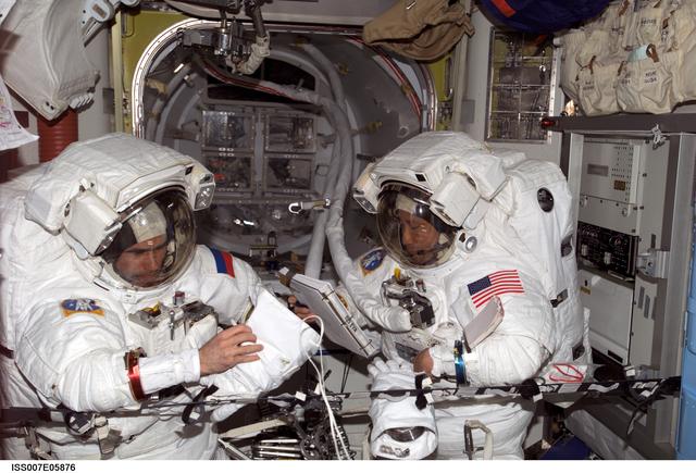 Expedition Seven CDR Malenchenko and Science Officer Lu in Quest airlock with EMUs