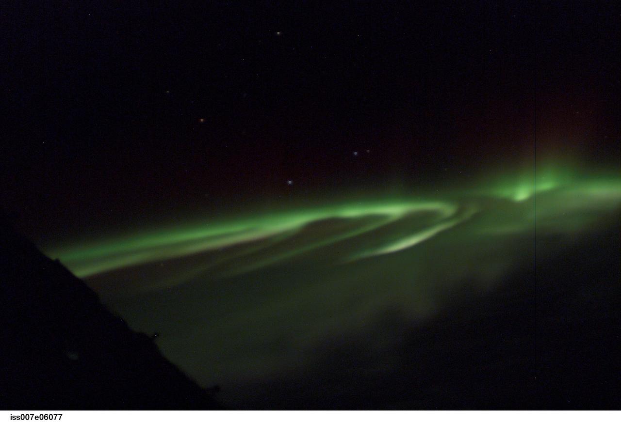 ISS007-E-06077 (3 June 2003) --- This view featuring the Aurora Australis or &#0147;southern lights&#0148; was photographed by astronaut Edward T. Lu, Expedition 7 NASA ISS science officer and flight engineer aboard the International Space Station (ISS). When this was taken, the Station was in a position over the Indian Ocean, southwest of Australia. The four stars hanging above Earth&#0146;s limb are the brightest stars of the southern constellation Corvus.