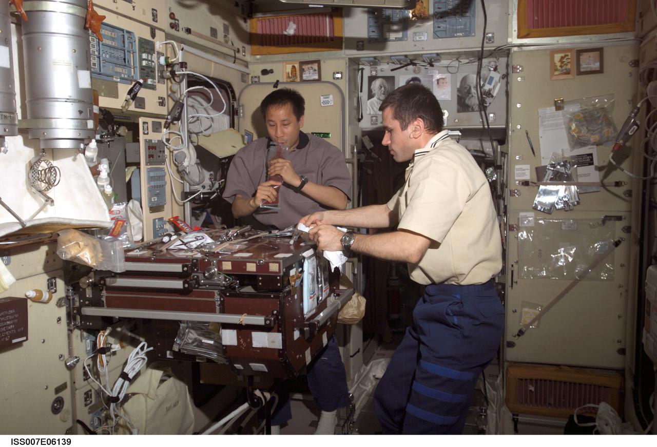 ISS007-E-06139 (1 June 2003) --- Cosmonaut Yuri I. Malenchenko (right), Expedition 7 mission commander, and astronaut Edward T. Lu, NASA ISS science officer and flight engineer, share a meal in the Zvezda Service Module on the International Space Station (ISS). Malenchenko represents Rosaviakosmos.