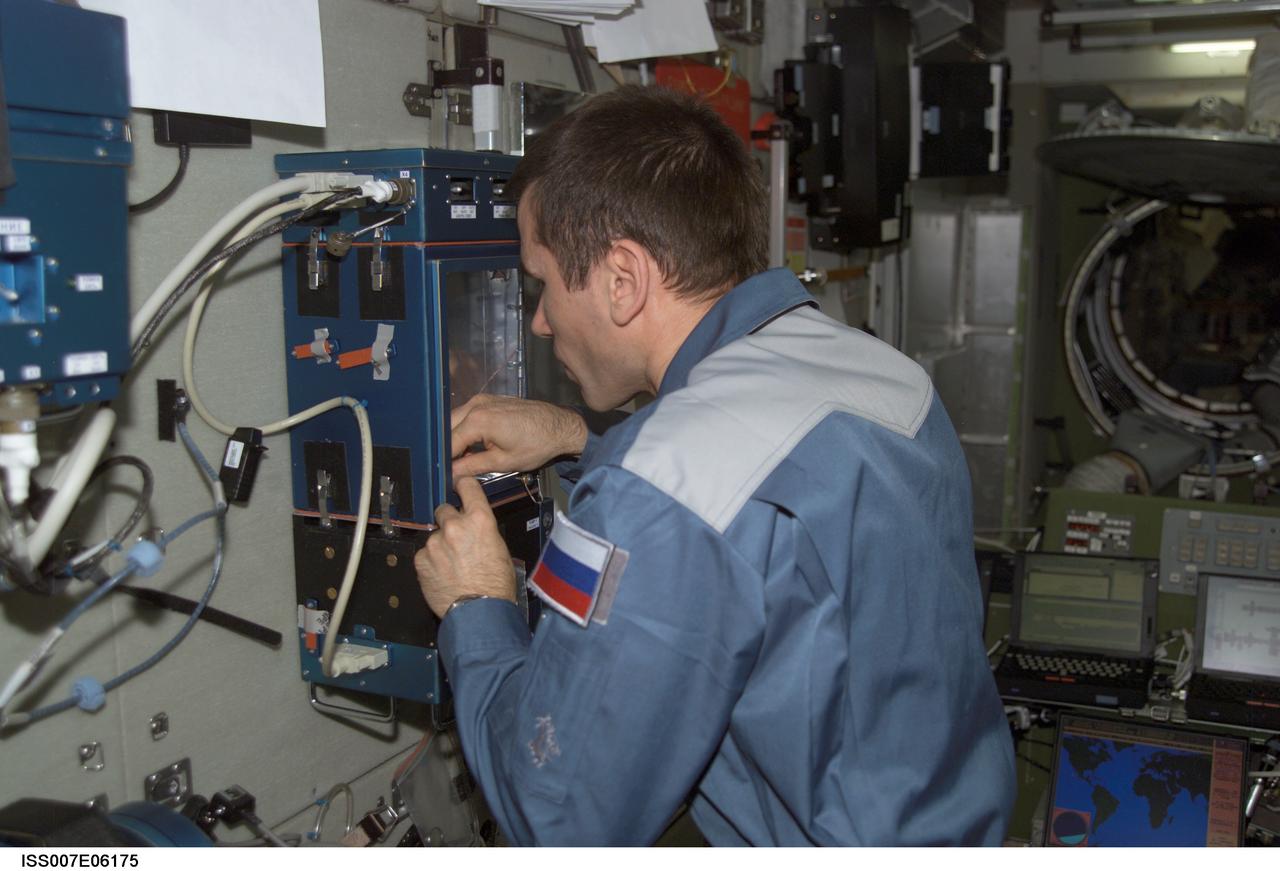 ISS007-E-06175 (21 May 2003) --- Cosmonaut Yuri I. Malenchenko, Expedition 7 mission commander, works with the Russian Lada greenhouse in the Zvezda Service Module on the International Space Station (ISS). Malenchenko represents Rosaviakosmos.