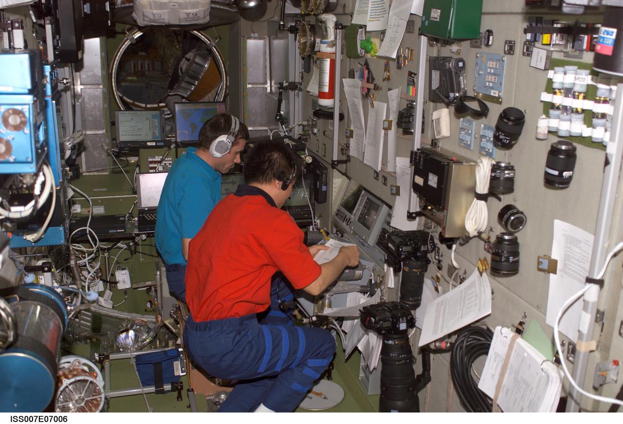 ISS007-E-07006 (11 June 2003) --- Cosmonaut Yuri I. Malenchenko (background), Expedition 7 mission commander, and astronaut Edward T. Lu, NASA ISS science officer and flight engineer, work in the Zvezda Service Module on the International Space Station (ISS). Malenchenko represents Rosaviakosmos.