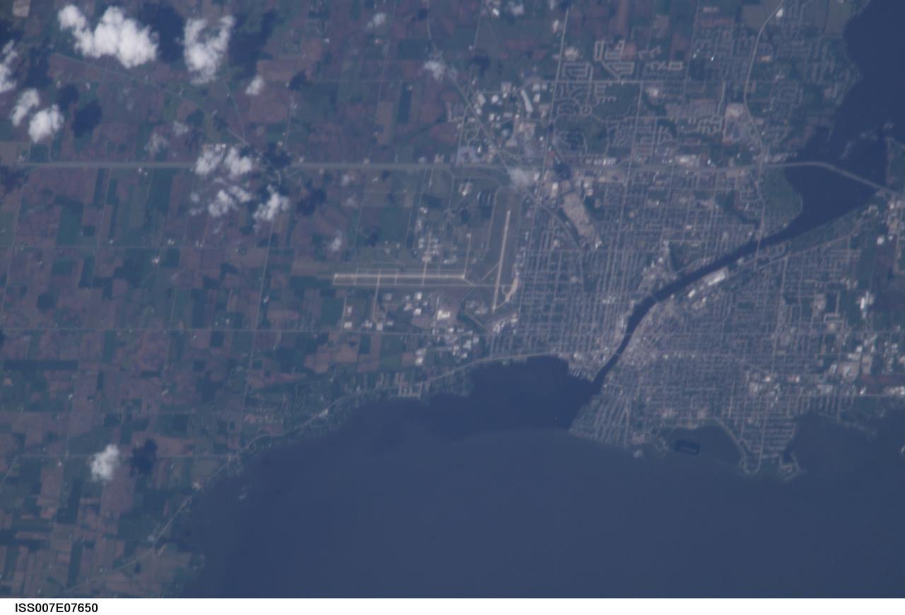 ISS007-E-07650 (July 2003) --- Part of Oshkosh, Wisconsin, site of a very popular air show, held around this time of year, was photographed by a crew member aboard the International Space Station during its seventh habitation mission.  The airfield near  Lake Winnebago hosts the mid-summer  fly-in event sponsored by the Experimental Aircraft Association (EAA).