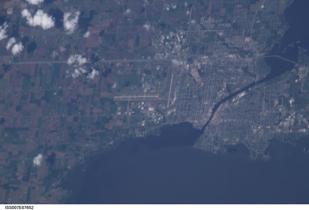 ISS007-E-07652 (July 2003) --- Part of Oshkosh, Wisconsin, site of a very popular air show, held around this time of year, was photographed by a crew member aboard the International Space Station during its seventh habitation mission.  The airfield near  Lake Winnebago hosts the mid-summer  fly-in event sponsored by the Experimental Aircraft Association (EAA).