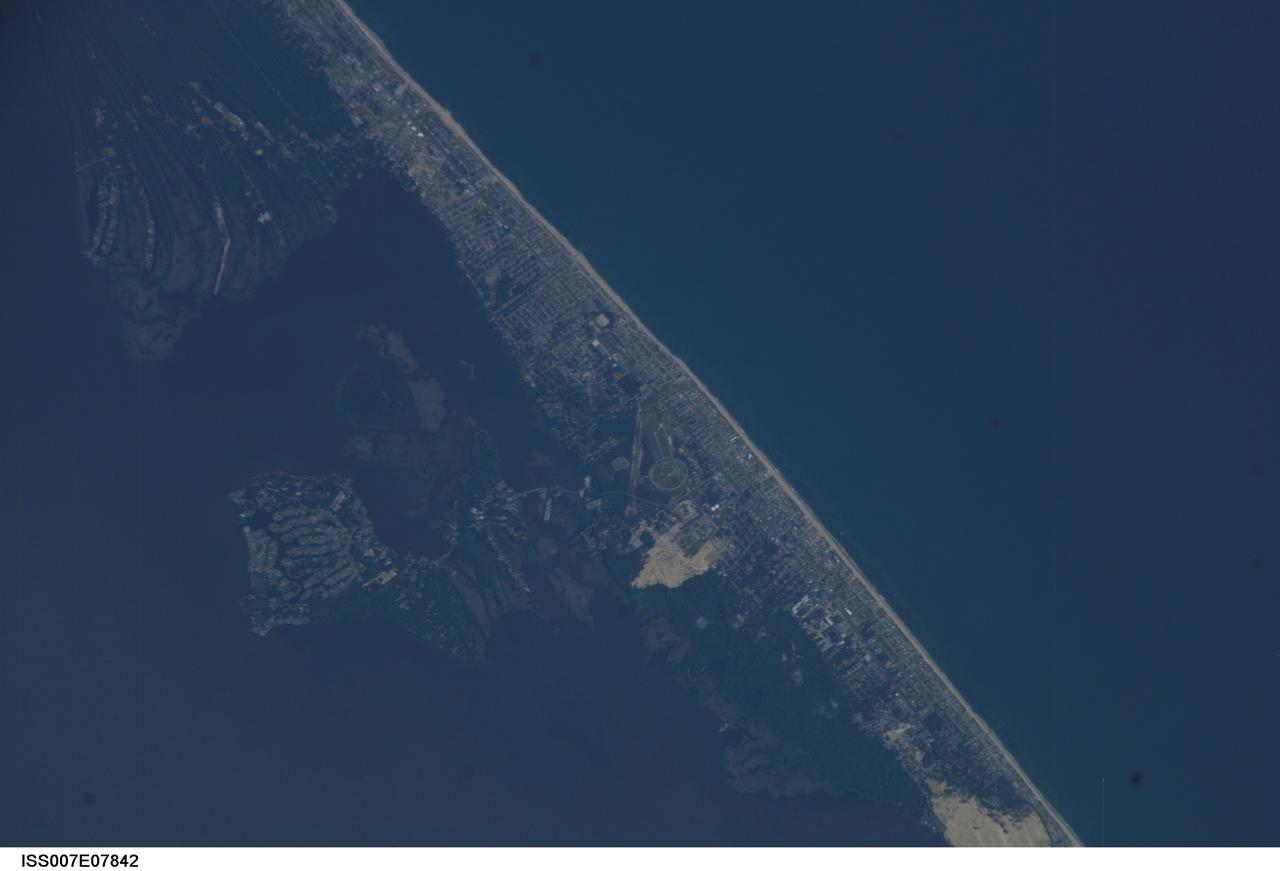 ISS007-E-07842 (22 June 2003) --- This image, photographed by an Expedition 7 crewmember onboard the International Space Station (ISS), features Kitty Hawk, N.C., on North Carolina&#0146;s Outer Banks. The view shows part of Pamlico Sound and the Atlantic side of the banks as well. This year the world celebrates a century of human flight with the 100th anniversary of the Wright Brothers' first flight at Kitty Hawk. The Wrights used the Outer Banks&#0146; prevailing winds and the altitude gained by climbing a 90-foot hill (Kill Devil Hill) to successfully demonstrate powered flight. The large circle on the image is a road that wraps around Kill Devil Hill, now part of the Wright Brothers National Memorial.