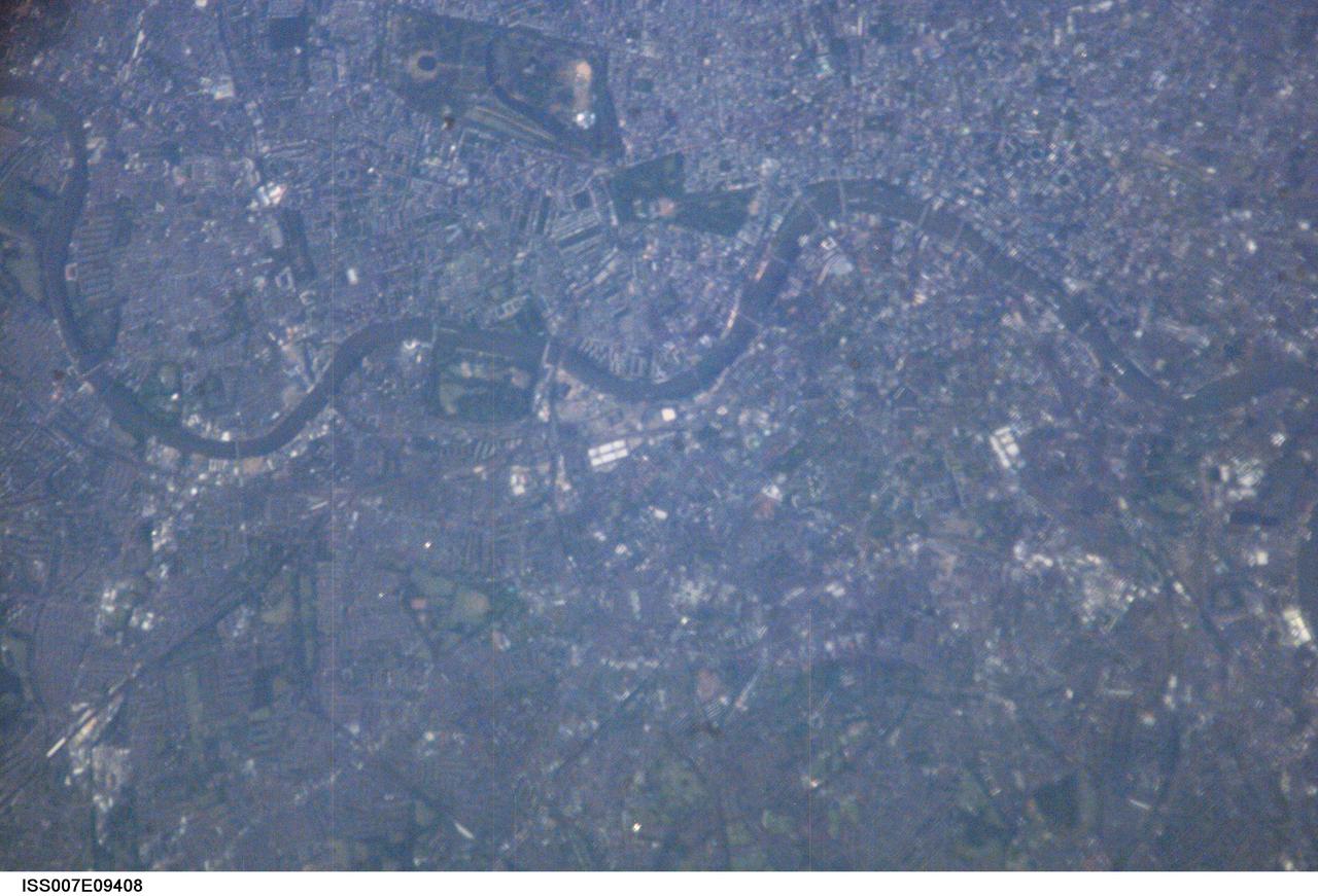 ISS007-E-09408 (5 July 2003) --- This nadir view of London, England, was downlinked from the International Space Station by one of the Expedition 7 crew members. A number of man-made landmarks are visible in the digital image, along with easily recognizable natural features, such as the River Thames, seen winding primarily in an East-West direction across the frame. The crew members could not help but be thinking of the Grand Slam Tournament being played at this time at the Wimbledon All England Tennis Club located in the south west of London. Wimbledon is just out of frame below the southwards bulge of the Thames.