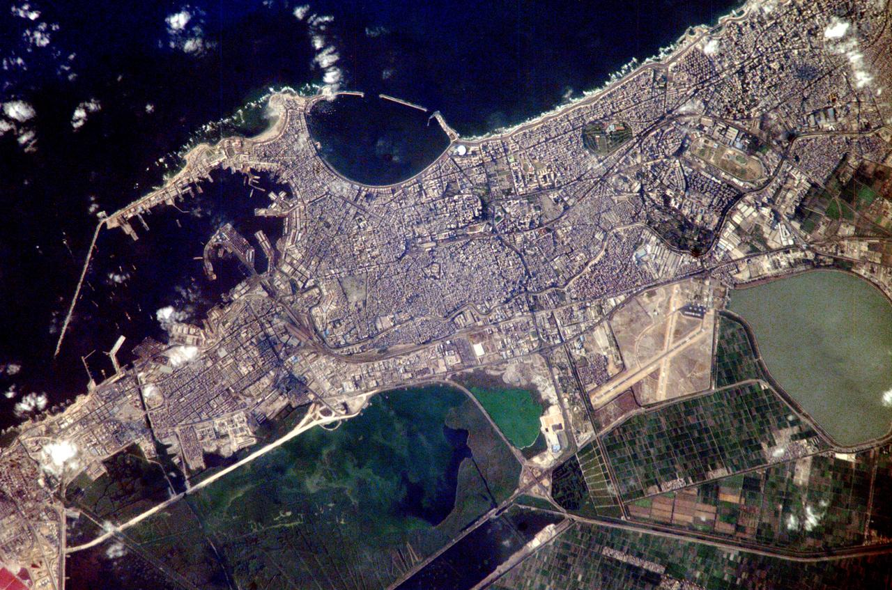 ISS007-E-10960 (27 July 2003) --- Alexandria, Egypt, is featured in this image photographed by an Expedition 7 crewmember on the International Space Station (ISS). Founded by Alexander the Great in 331 BC on the Mediterranean coast of Egypt, Alexandria became a center of trade and learning in the ancient world. Alexander built the causeway between the Eastern and Western Harbors, joining Pharos Island to the mainland. Alexandria&#0146;s cultural status was symbolized by the lighthouse on Pharos, one of the &#0147;Seven Wonders of the World.&#0148; The causeway is still known as the old part of the modern city. Since the year 2000, underwater archeologists have located the sunken palace, ceremonial buildings and port facilities of ancient Alexandria, located along most of the curved southern shoreline of the Eastern Harbor. This detailed image provides a view of the modern port facilities in the Western Harbor, where wharves and many moored ships can be detected.